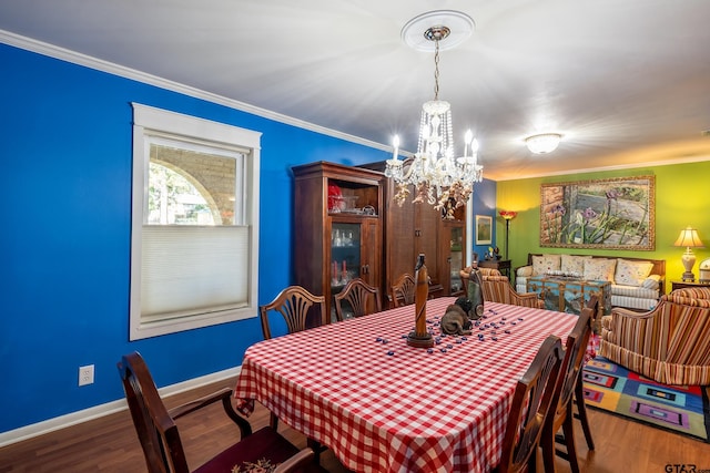 dining room with hardwood / wood-style floors, a notable chandelier, and crown molding