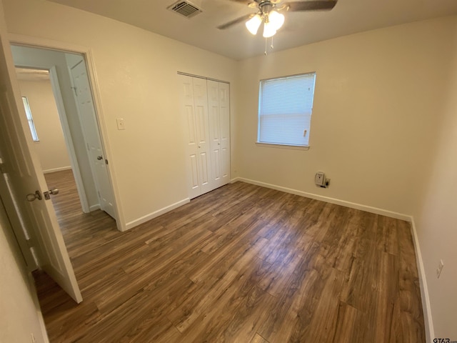 3903 Appletree Ln, Tyler, TX 75701 - unfurnished bedroom with dark wood-style flooring, a closet, multiple windows, and ceiling fan