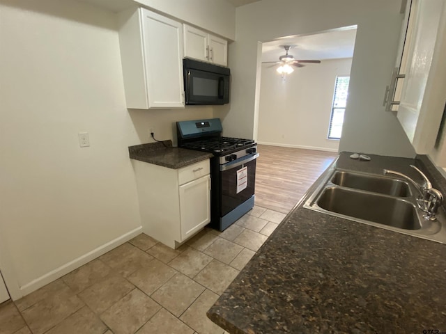 3903 Appletree Ln, Tyler, TX 75701 - kitchen featuring black microwave, stainless steel gas range, a ceiling fan, light tile patterned flooring, and white cabinetry