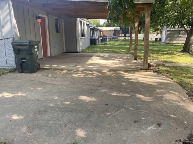 3903 Appletree Ln, Tyler, TX 75701 - view of patio with a carport, a trampoline, and concrete driveway