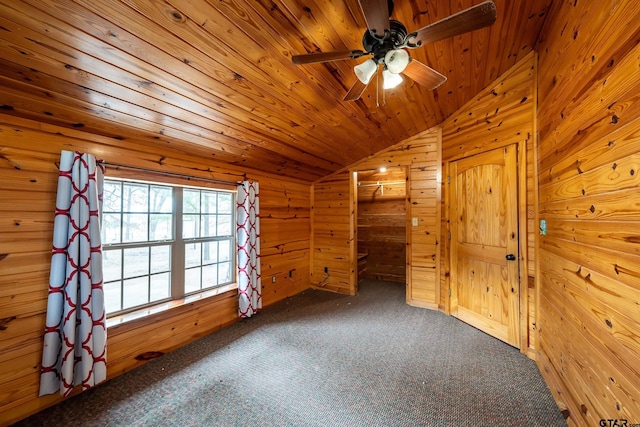 interior space featuring lofted ceiling, wood ceiling, wood walls, and carpet