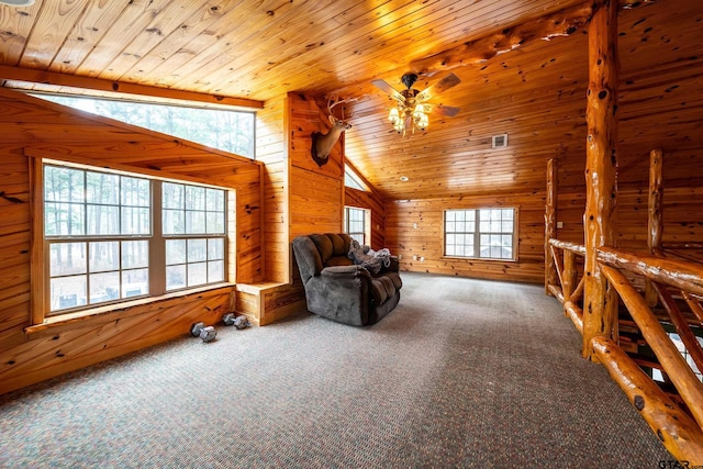 unfurnished room featuring lofted ceiling, a wealth of natural light, wooden walls, and carpet flooring