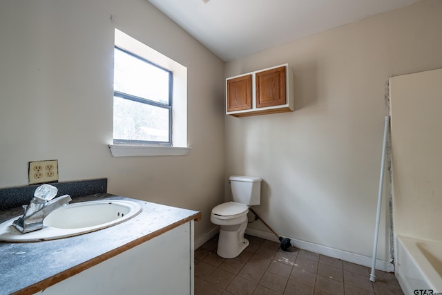 bathroom with vanity, a tub to relax in, tile patterned floors, and toilet