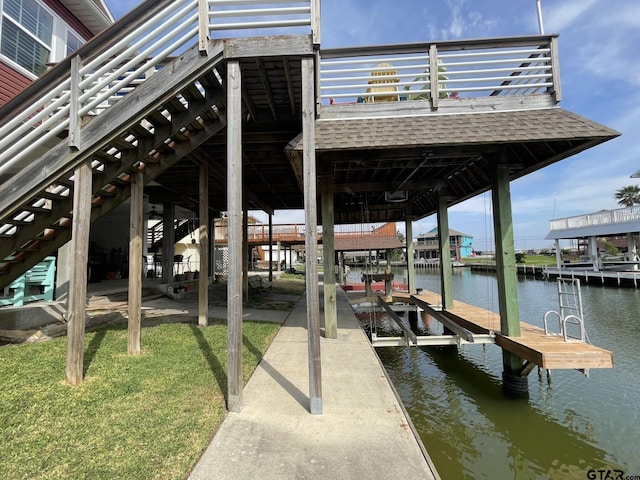 view of dock featuring a water view and a yard