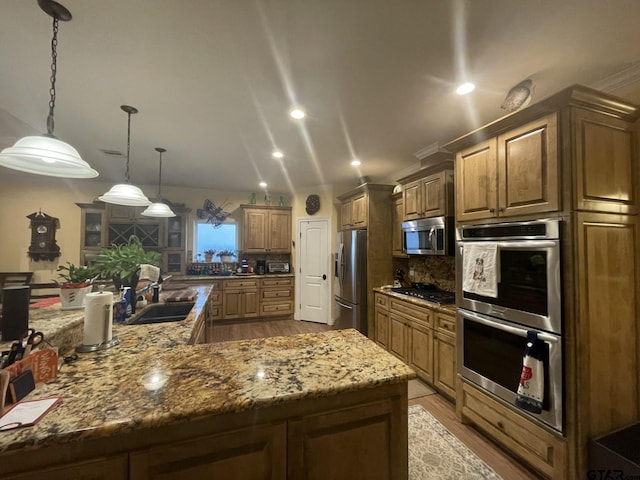 kitchen with light hardwood / wood-style floors, sink, appliances with stainless steel finishes, decorative light fixtures, and decorative backsplash