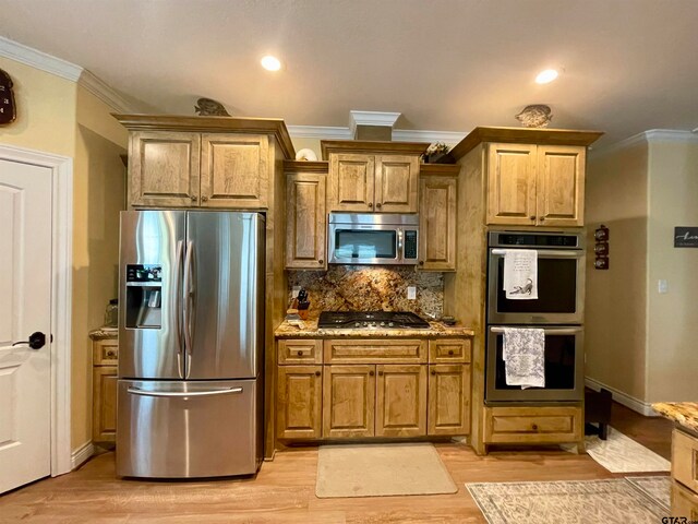 kitchen featuring ornamental molding, appliances with stainless steel finishes, light hardwood / wood-style flooring, and light stone countertops