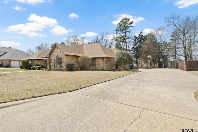 205 Turnberry Cir, Mount Pleasant, TX 75455 - view of home's exterior featuring driveway, a chimney, a shingled roof, and brick siding