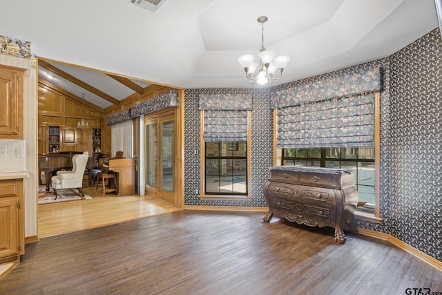 205 Turnberry Cir, Mount Pleasant, TX 75455 - interior space with a chandelier, wallpapered walls, wood finished floors, vaulted ceiling, and a raised ceiling