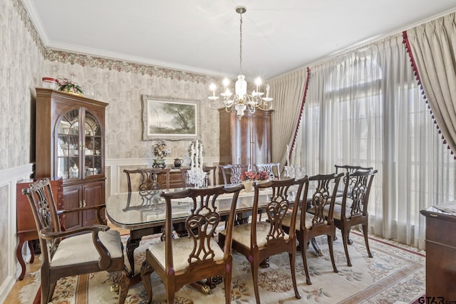 205 Turnberry Cir, Mount Pleasant, TX 75455 - dining space featuring a chandelier, a wainscoted wall, wallpapered walls, ornamental molding, and wood finished floors