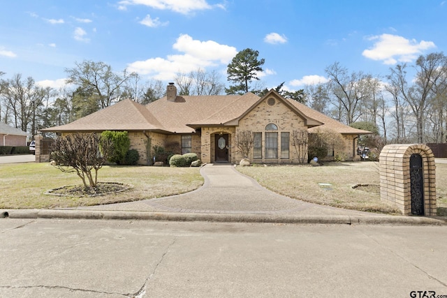 205 Turnberry Cir, Mount Pleasant, TX 75455 - view of front facade with brick siding, a front lawn, a chimney, and roof with shingles