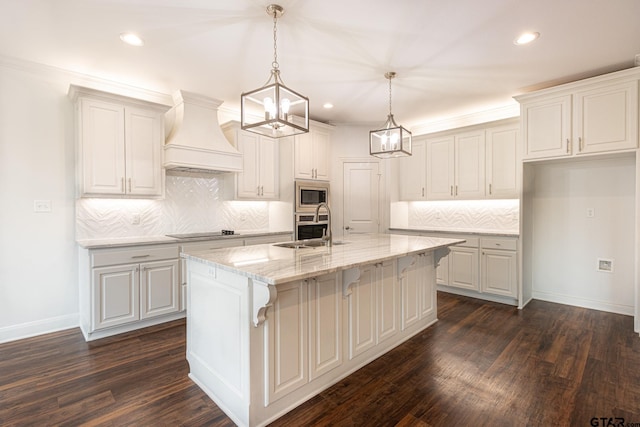 kitchen with appliances with stainless steel finishes, dark wood-type flooring, a center island with sink, and sink