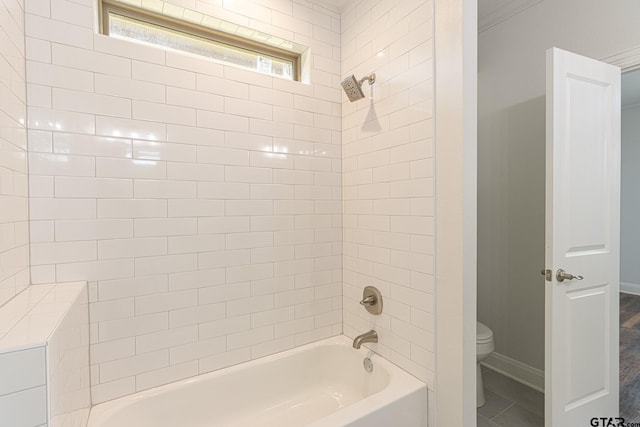 bathroom featuring toilet, tiled shower / bath, and ornamental molding