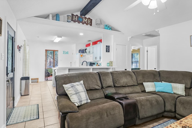 living room featuring lofted ceiling with beams, light tile patterned flooring, sink, and ceiling fan