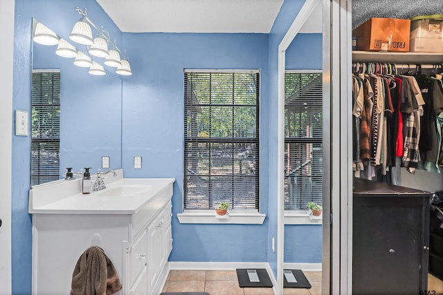 bathroom featuring vanity, tile patterned flooring, a textured ceiling, and a notable chandelier