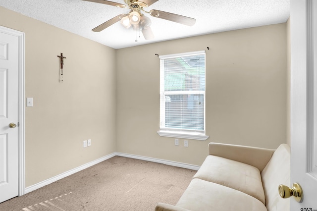 sitting room featuring ceiling fan, carpet floors, and a textured ceiling