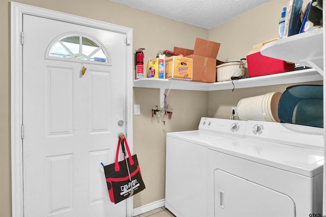 clothes washing area featuring washing machine and dryer and a textured ceiling