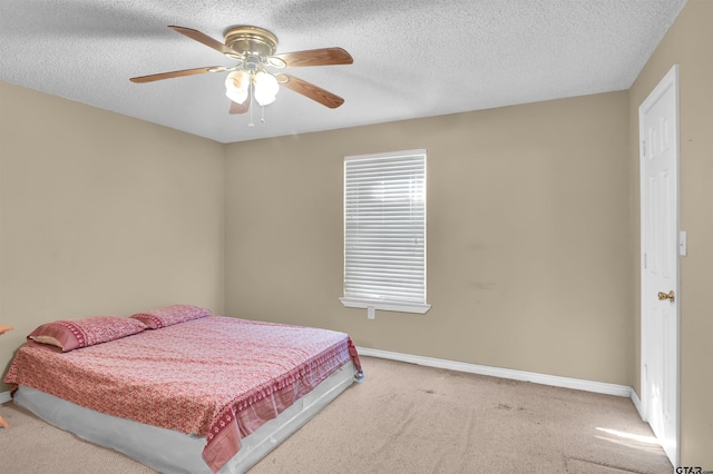 bedroom with ceiling fan, light carpet, and a textured ceiling