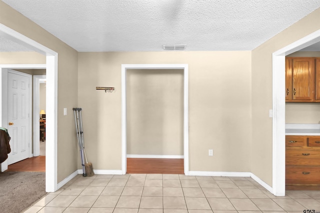 empty room featuring light tile patterned flooring and a textured ceiling