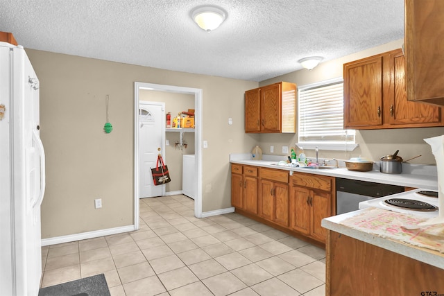 kitchen with sink, light tile patterned floors, a textured ceiling, and white fridge