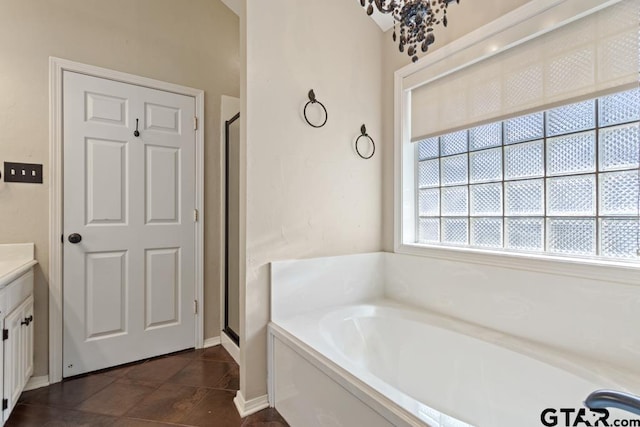 full bath with vanity, tile patterned floors, baseboards, a garden tub, and a stall shower