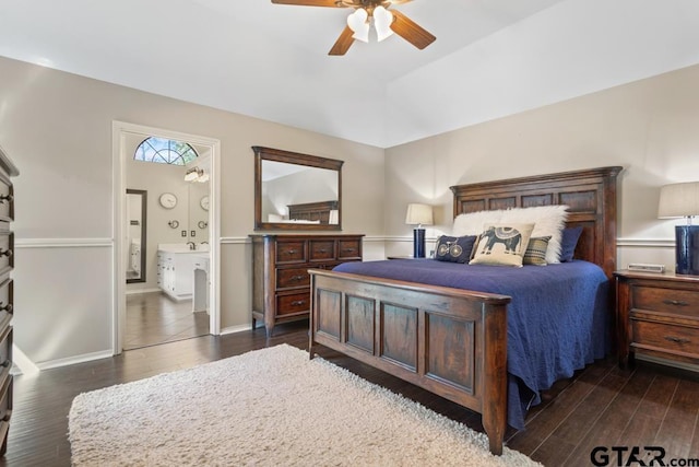 bedroom with ceiling fan, vaulted ceiling, baseboards, connected bathroom, and dark wood-type flooring