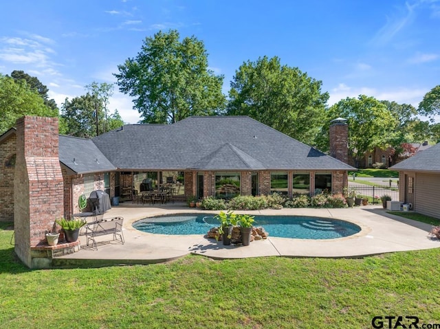 outdoor pool featuring a lawn, fence, and a patio area