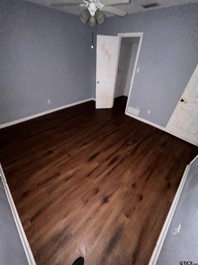 unfurnished room featuring ceiling fan and dark wood-type flooring