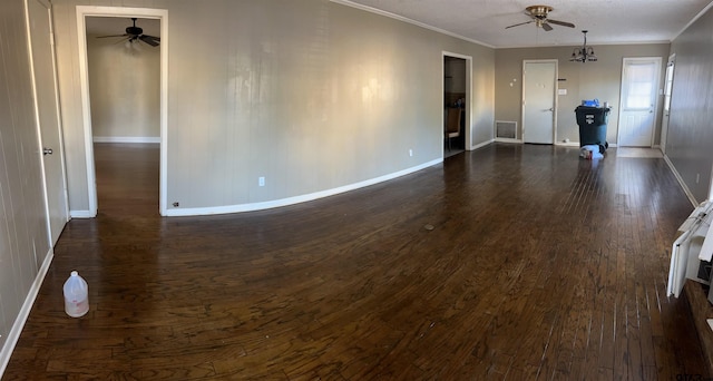 unfurnished living room with ornamental molding, dark wood-type flooring, and a notable chandelier