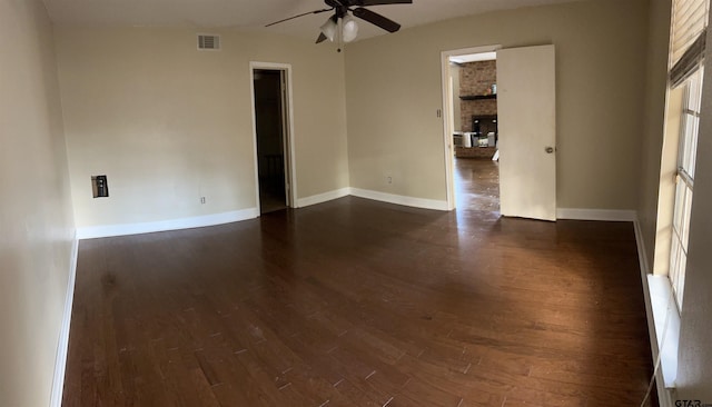 empty room with dark hardwood / wood-style flooring and ceiling fan