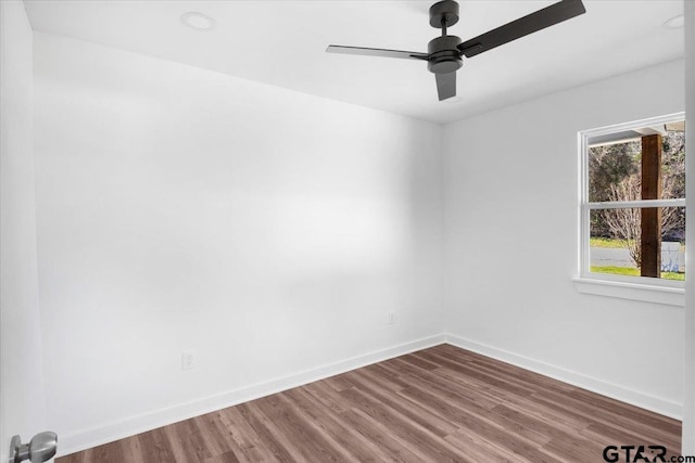 empty room featuring a ceiling fan, baseboards, and wood finished floors