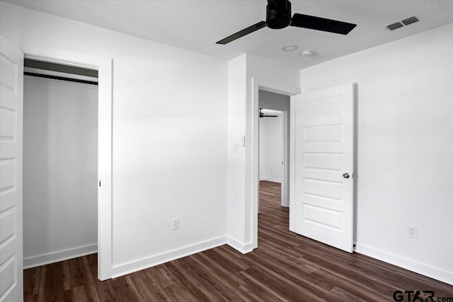 unfurnished bedroom with visible vents, baseboards, dark wood-type flooring, and a ceiling fan