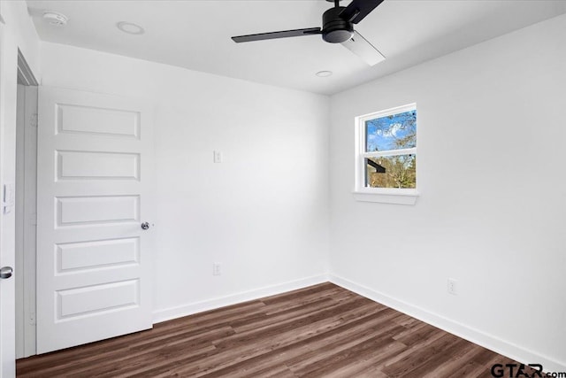 unfurnished room with a ceiling fan, dark wood-style floors, and baseboards