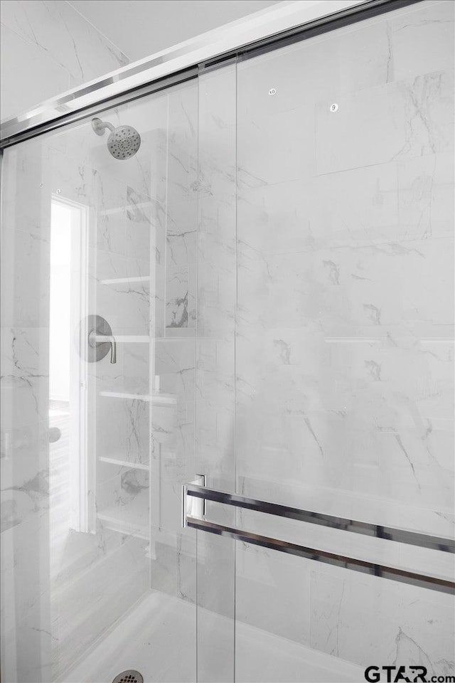 full bathroom with a marble finish shower