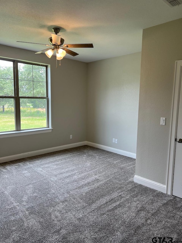 carpeted spare room featuring ceiling fan