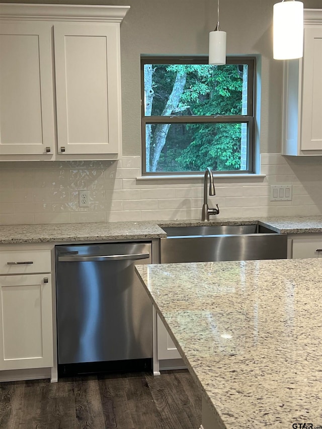 kitchen featuring dark wood-type flooring, stainless steel dishwasher, hanging light fixtures, and white cabinets