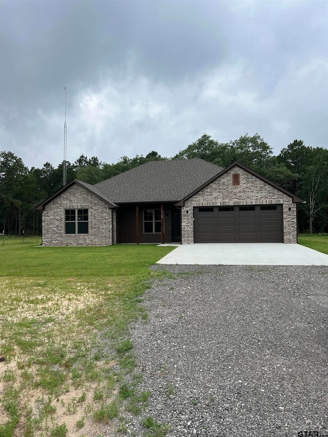 single story home with a garage and a front lawn