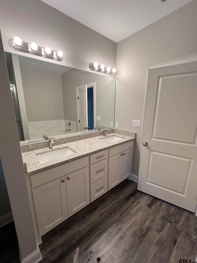 bathroom with hardwood / wood-style floors, vanity, and a bathing tub