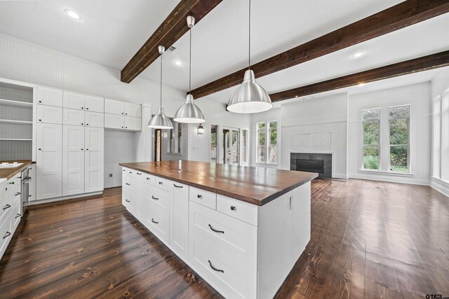 23611 Ridgeview Dr, Bullard, TX 75757 - kitchen featuring butcher block counters, dark wood-style floors, healthy amount of natural light, a fireplace, and beamed ceiling