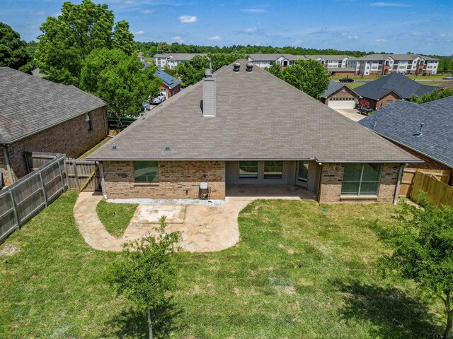 2056 Balsam Gap, Tyler, TX 75703 - back of house with a fenced backyard, brick siding, a yard, and a patio