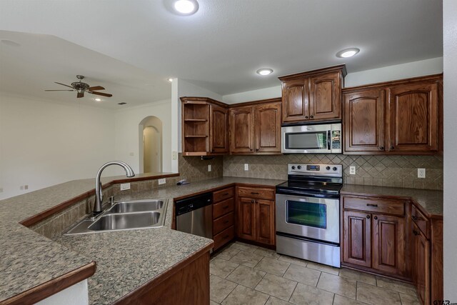 2056 Balsam Gap, Tyler, TX 75703 - kitchen featuring open shelves, a sink, ceiling fan, arched walkways, and appliances with stainless steel finishes