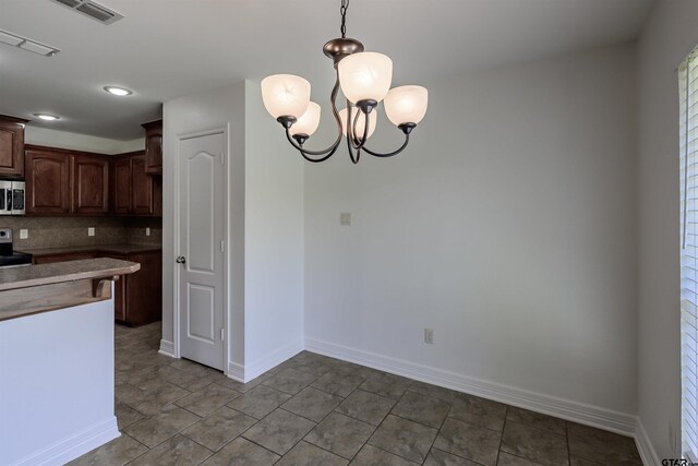 2056 Balsam Gap, Tyler, TX 75703 - kitchen featuring stainless steel appliances, dark brown cabinets, visible vents, decorative light fixtures, and tasteful backsplash