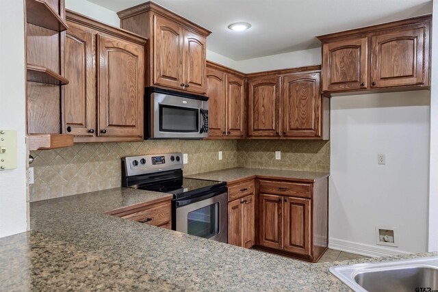 2056 Balsam Gap, Tyler, TX 75703 - kitchen with brown cabinets, tasteful backsplash, stainless steel appliances, and dark countertops