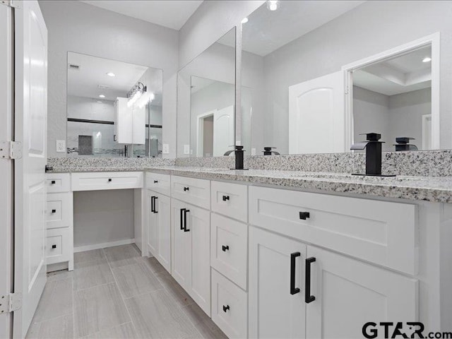 bathroom featuring double vanity and walk in shower