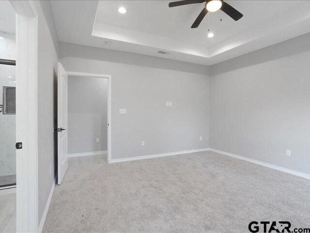 unfurnished room featuring recessed lighting, baseboards, a tray ceiling, and light colored carpet