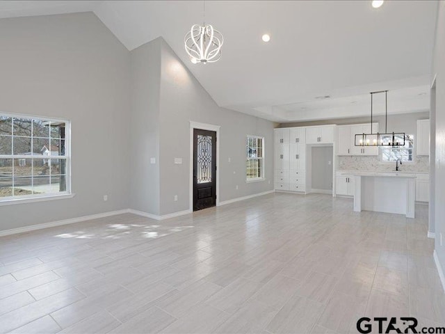 unfurnished living room with a healthy amount of sunlight and an inviting chandelier