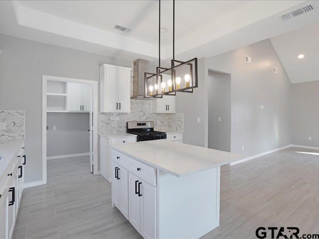 kitchen with wall chimney exhaust hood, visible vents, tasteful backsplash, and stainless steel range with gas stovetop