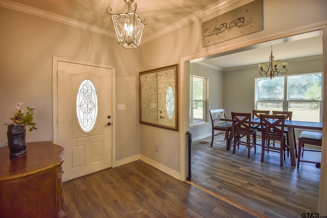 foyer entrance with dark hardwood / wood-style floors, ornamental molding, and a notable chandelier