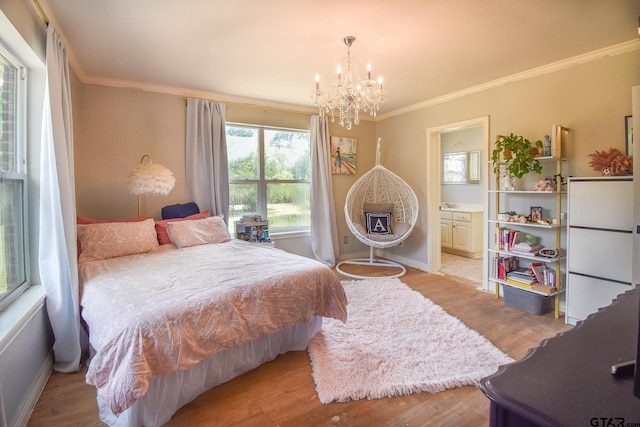 bedroom with ensuite bath, ornamental molding, a notable chandelier, and light wood-type flooring