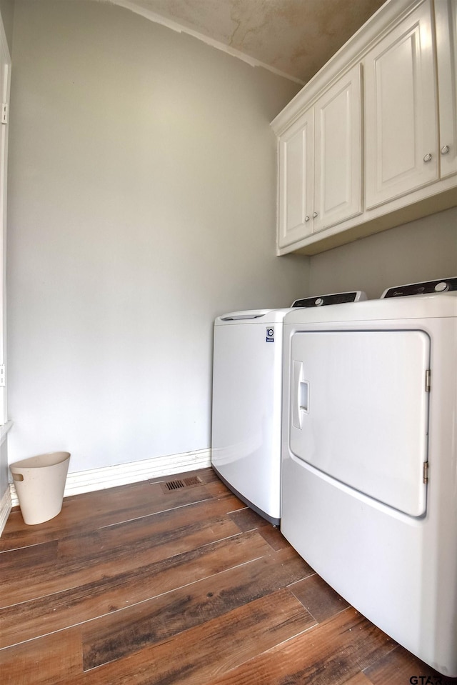 washroom featuring dark hardwood / wood-style floors, cabinets, and separate washer and dryer