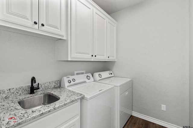 washroom featuring independent washer and dryer, dark hardwood / wood-style flooring, cabinets, and sink